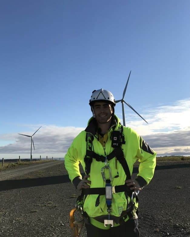 Harrison Mallan in hi-vis and a safety harness on a wind farm.